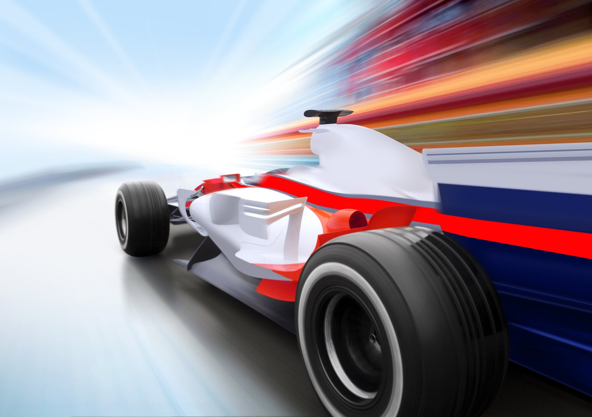 Formula 1 race car in red, white, and blue livery racing at high speed with motion blur background