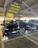 Two parked cars in a covered parking garage with yellow safety signage overhead