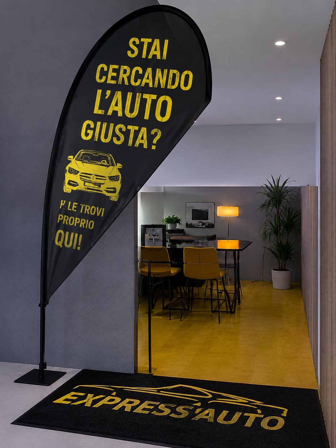 Black teardrop banner with yellow text and car icon outside an auto dealership showroom with yellow floor